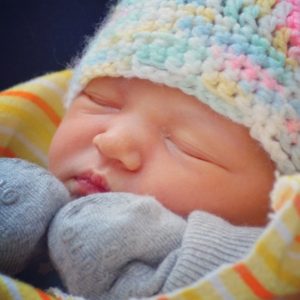 a beautiful close-up of my daughter very shortly after her birth in February 2016, wearing a pastel-coloured knit touque (aka the turban)